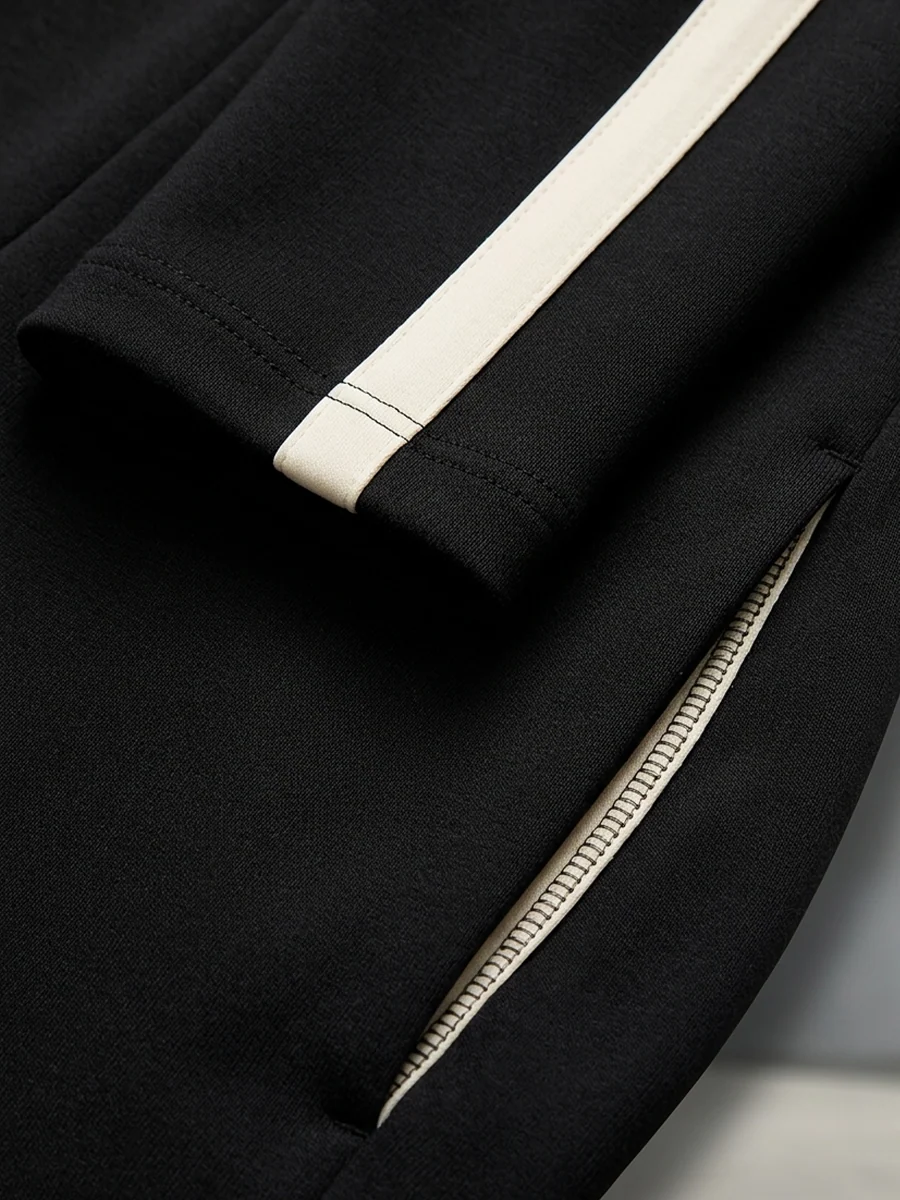 CIRILLA | Ensemble de sport noir avec demi-fermeture éclair, rayures contrastées et pantalon ample